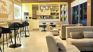 A modern interior with a dining area, kitchen, and seating space. - Soeltan Luxe Hotel (Bandar Lampung)