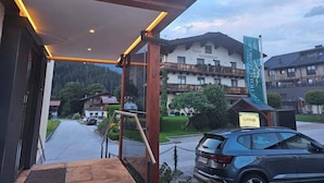 La entrada del Die Hotel Pension, con un área exterior techada y vistas de los edificios y la calle circundantes.