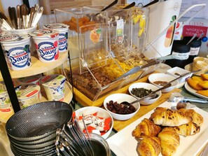 Een ontbijtbuffet met diverse gerechten en toevoegingen.