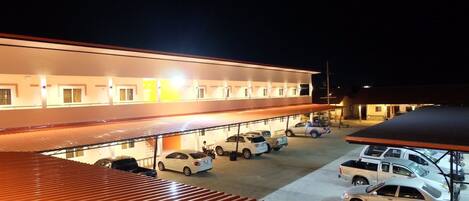 A multi-story hotel with a parking area in front.