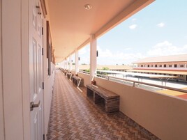 Un pasillo con bancos y vista a una estación de tren.