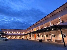 Un hotel de varios pisos con un área exterior cubierta y varios balcones.