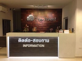 Un mostrador de recepción con un fondo de pared de madera, un logotipo y un cartel que dice "INFORMATION".