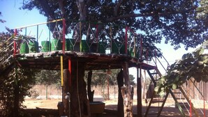 Un parque infantil con una estructura de madera, columpios y un tobogán.