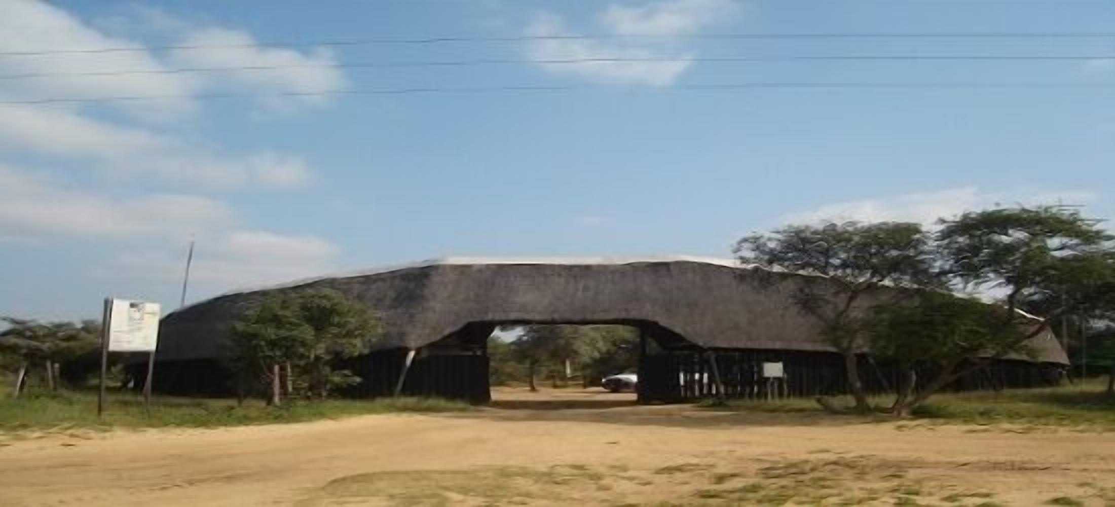 A large, arched bridge structure with a dirt road leading through it.