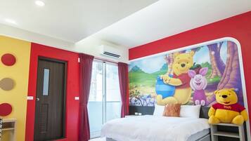 Habitación de hotel con una cama, una ventana con cortinas rojas, una pared con diseños circulares y un peluche de Winnie the Pooh sobre la cama.
