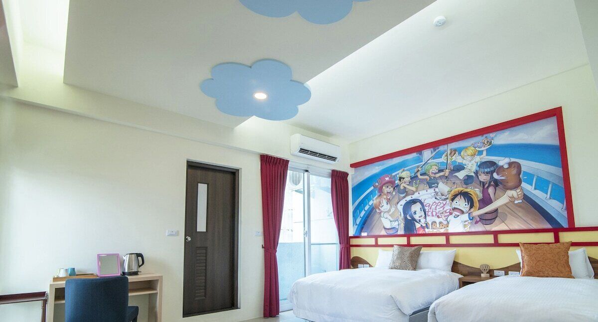 Habitación de hotel con dos camas, un escritorio con silla, un cuadro en la pared y una puerta con ventanal.