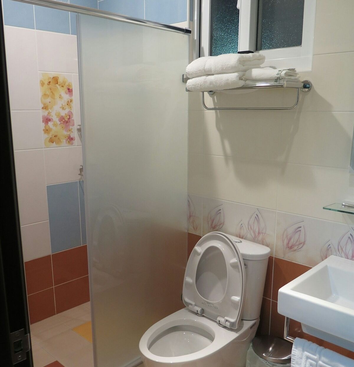A bathroom with a toilet, a shower enclosure, and a sink.