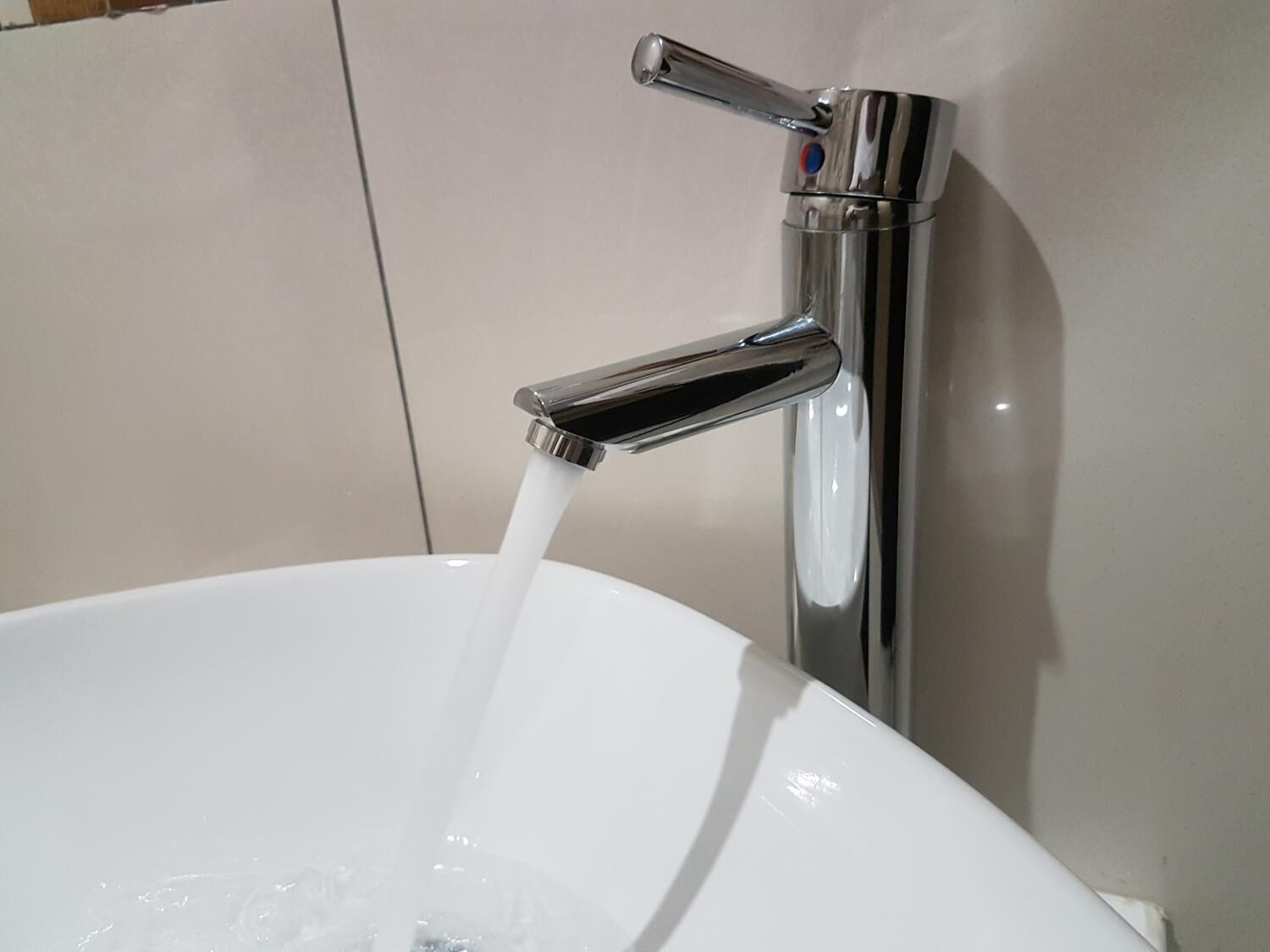 Un baño moderno con grifo de cromo y lavabo blanco.