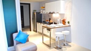 Uma cozinha compacta com área de refeições, um pequeno espaço de estar e um balcão com banquetas.