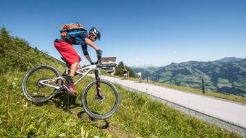 Ciclista de montanha numa trilha com vista ampla da paisagem ao redor.