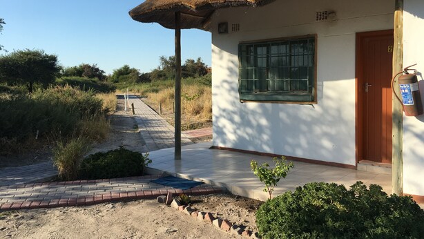 Un edificio con techo de paja, una ventana y una puerta.