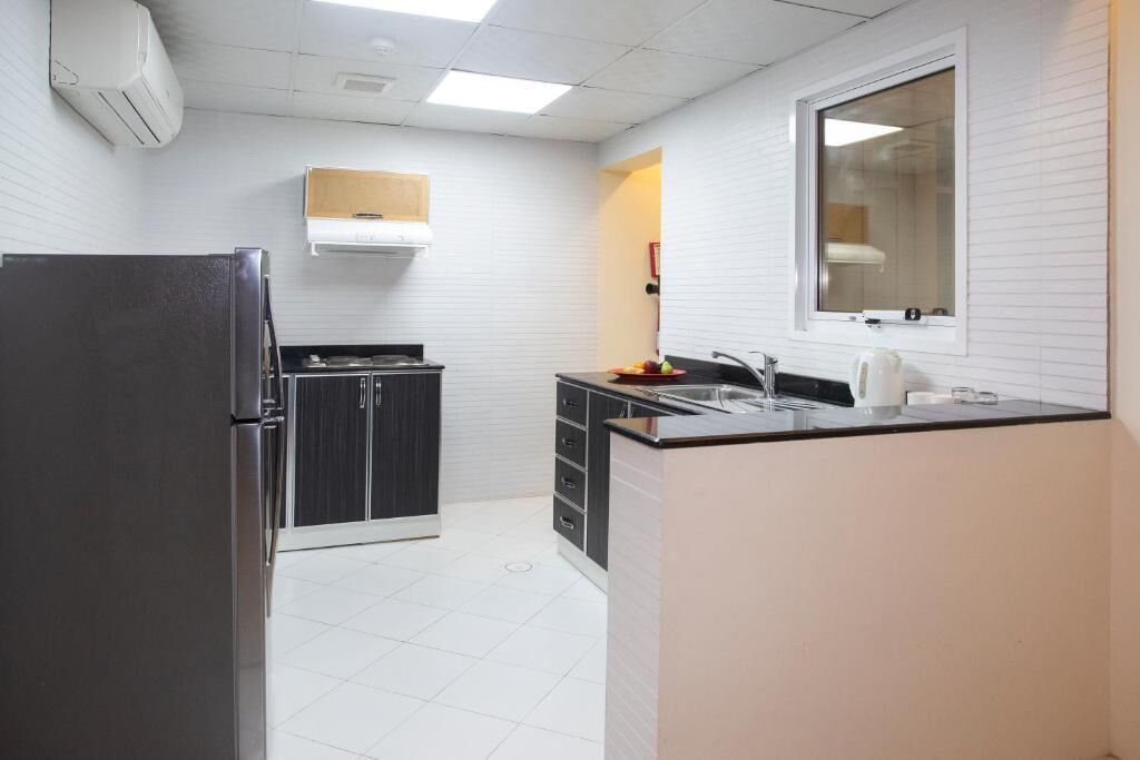 A compact kitchen with a refrigerator, stove, and sink.