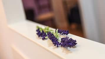 Uma superfície branca com um arranjo de flores roxas.