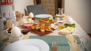 Ein Esstisch ist gedeckt mit Tellern, Besteck und verschiedenen Speisen.