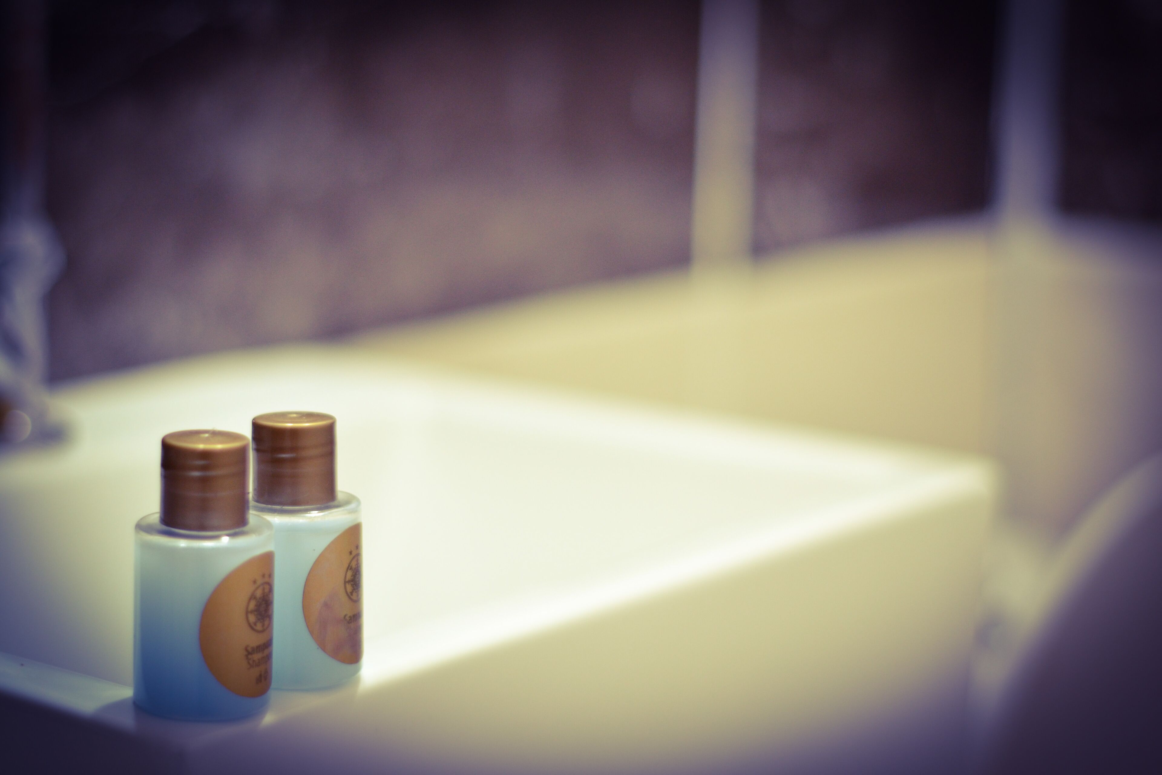 Two bottles of liquid on a white surface, likely a bathroom sink.