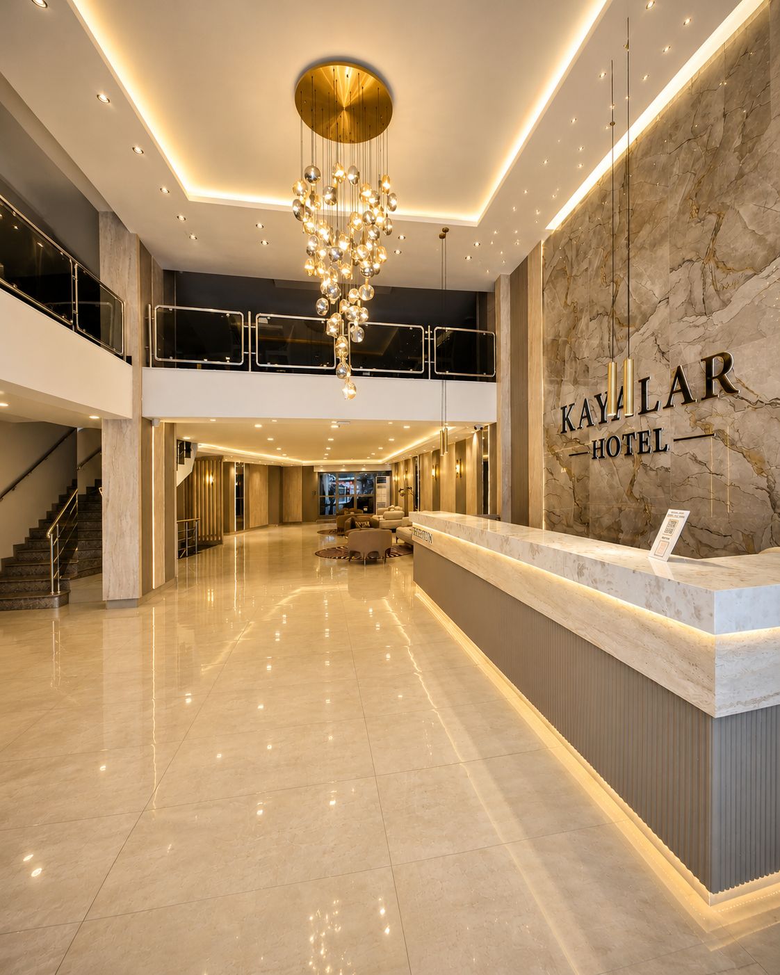 Eine Hotelhalle mit einem мраморном Empfangsschalter, einem Chandelier und einer Treppe.