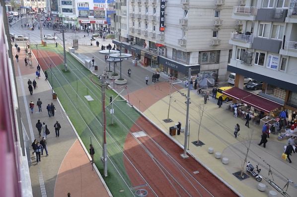 A busy urban street with a tram line, shops, and a hotel. - Hotel Kayalar (Antalya)