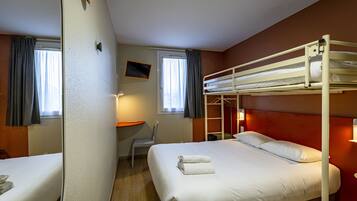 Une chambre d’hôtel avec un lit superposé, un bureau et une chaise.