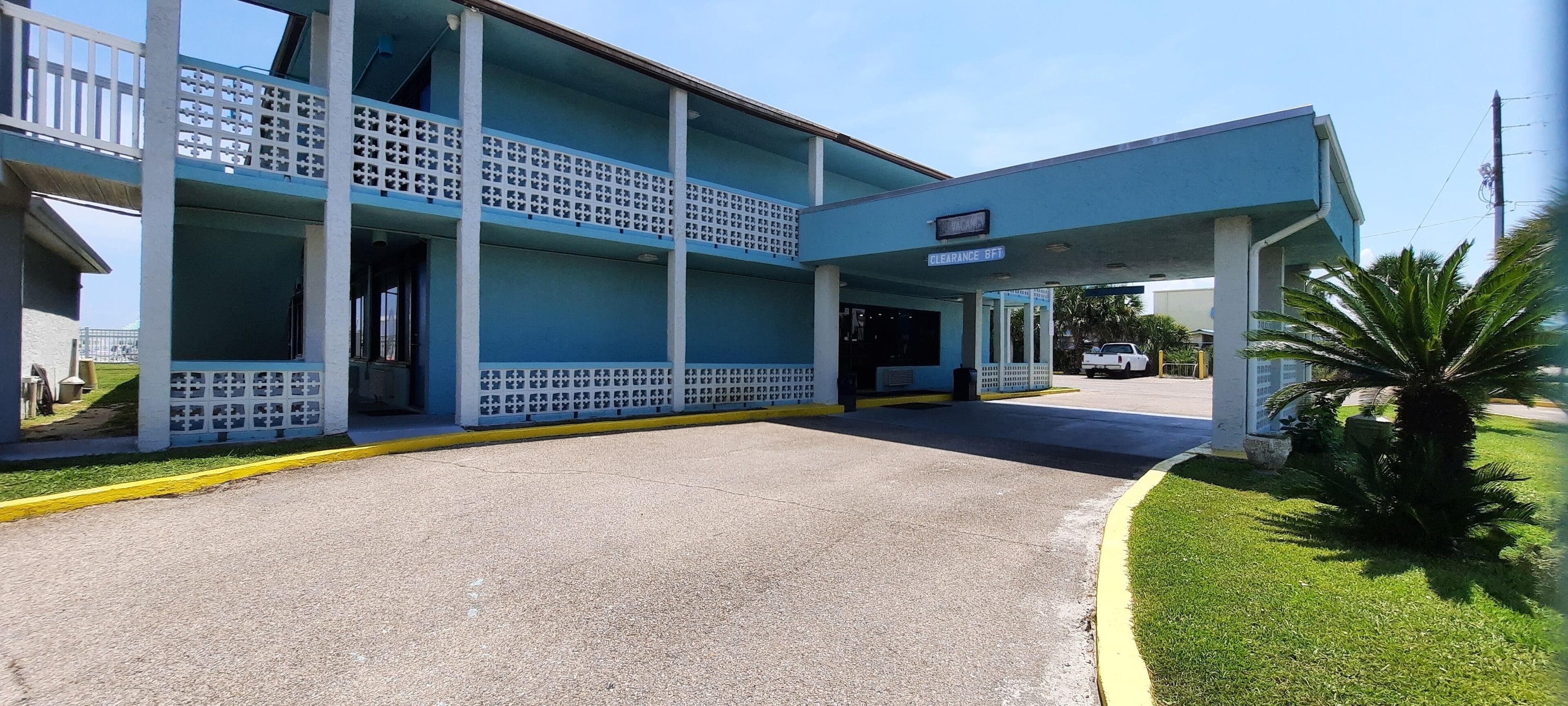 A two-story building with a covered entrance and a sign indicating a clearance area.