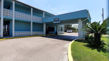 A two-story building with a covered entrance and a sign indicating a clearance area.