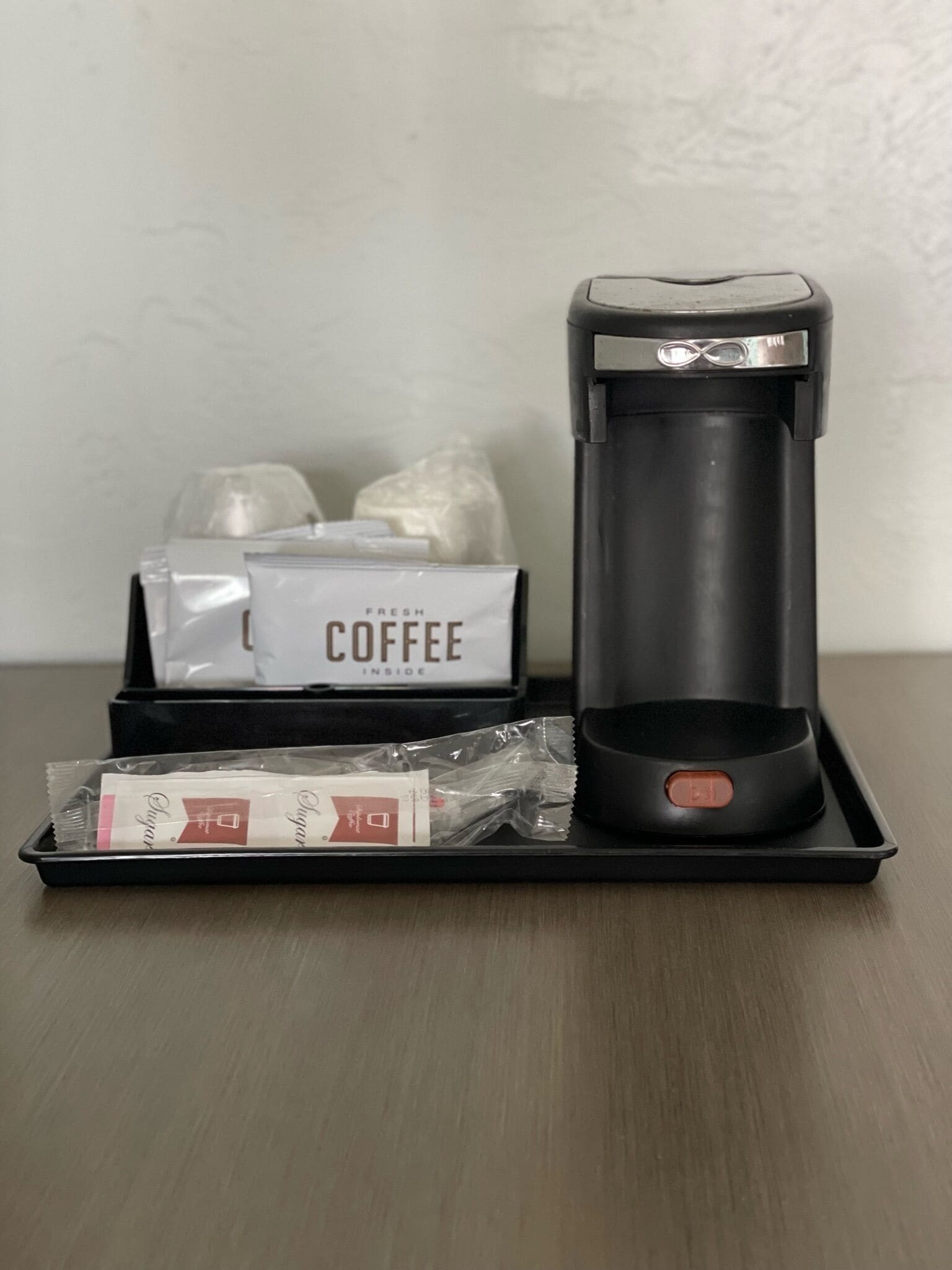 Une machine à café, un plateau avec des dosettes de café et une boîte étiquetée « CAFÉ ».