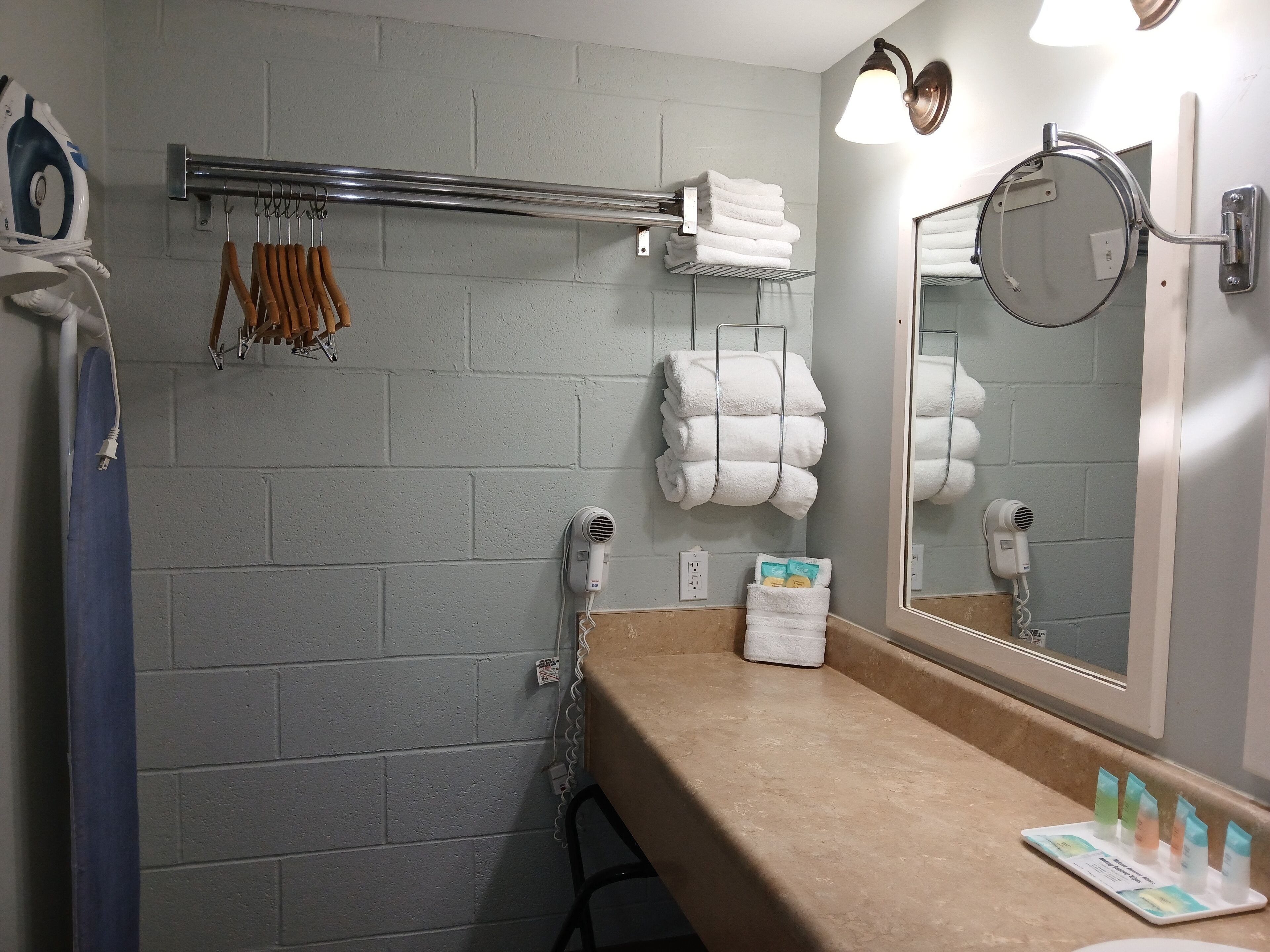 A bathroom with a towel rack, a mirror, and a sink.