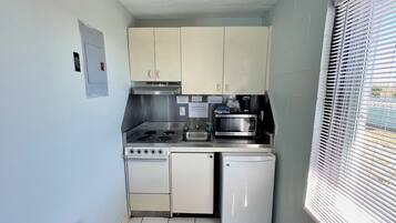 Cozinha compacta com fogão, micro-ondas e lava-louças.