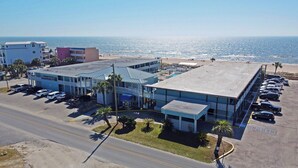 A beachfront hotel with a parking lot, a pool, and a view of the ocean. - Buccaneer Inn (St. George Island)