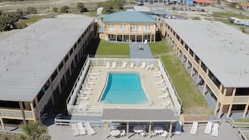 Relax by the hotel's central pool, surrounded by a covered deck with lounge chairs and tables.