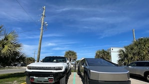 A parking space marked "EV CHARGING ONLY" with two vehicles parked. - Buccaneer Inn (St. George Island)