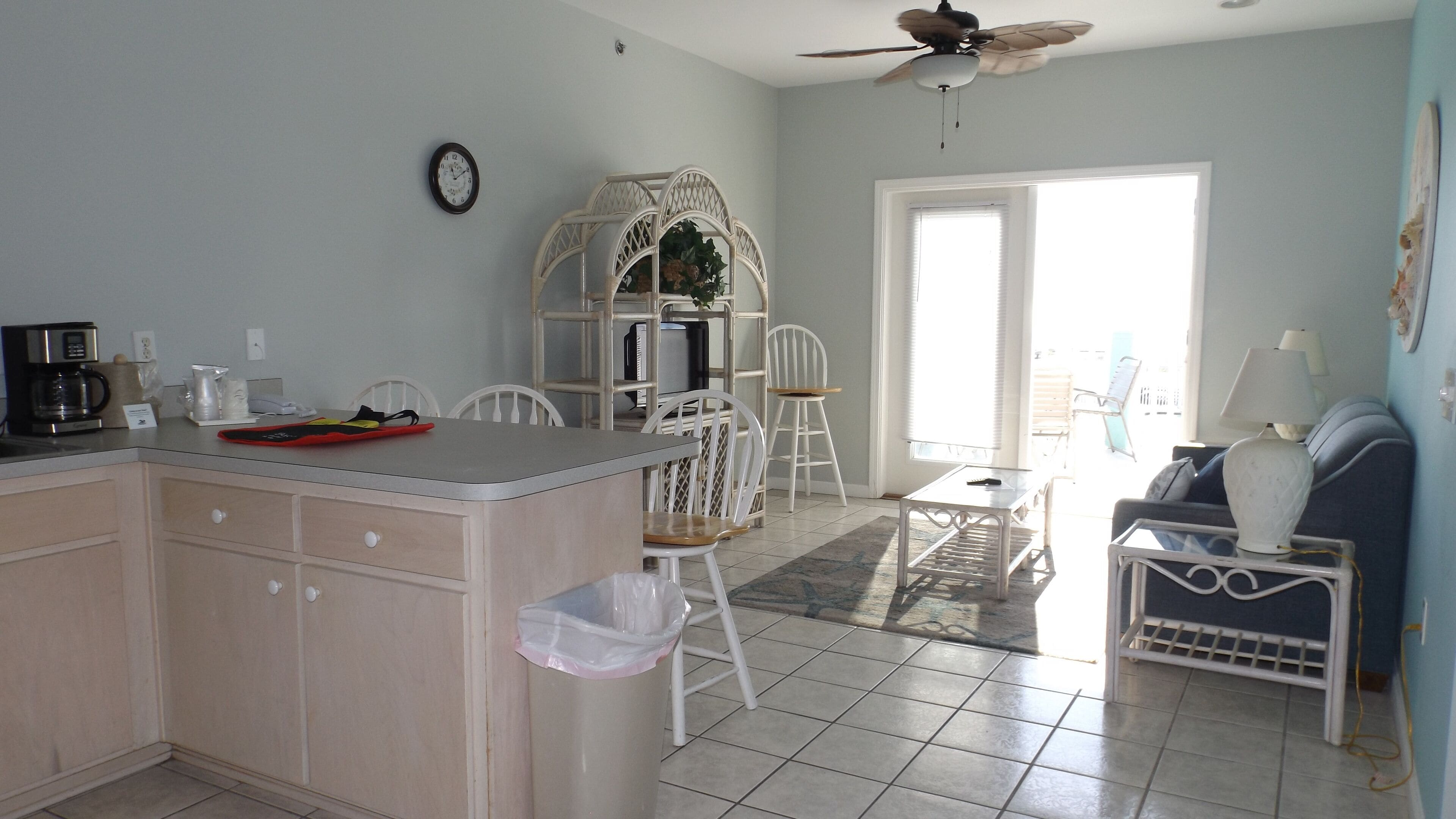 A kitchen with a dining area, a ceiling fan, and a view through a door.