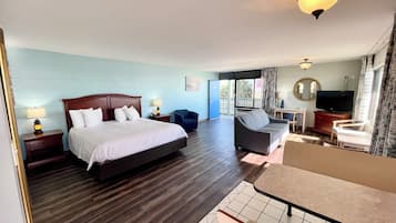 Une chambre d’hôtel avec un grand lit, un canapé, une télévision et un bureau.