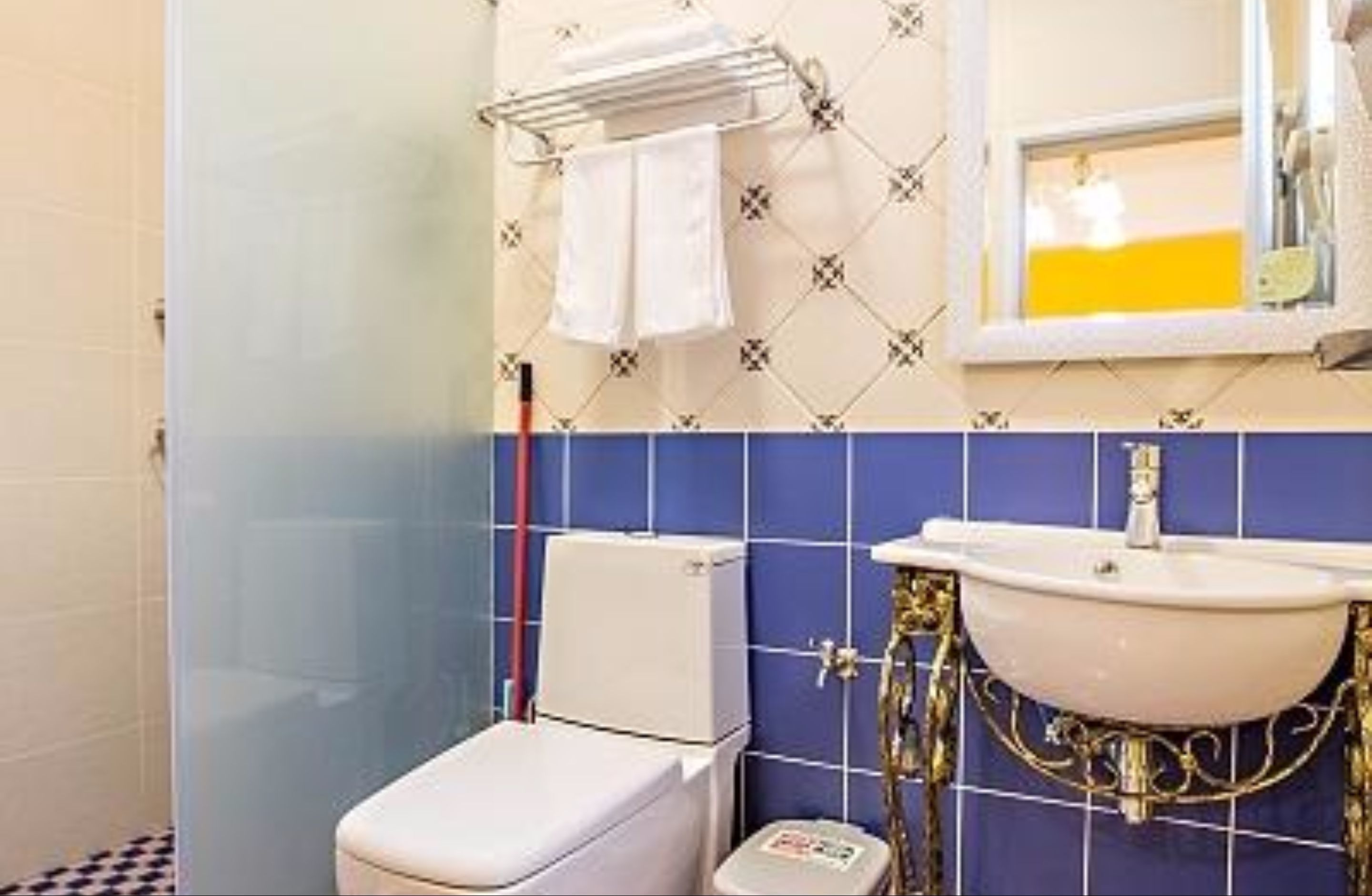 A bathroom with a toilet, sink, and towel rack.