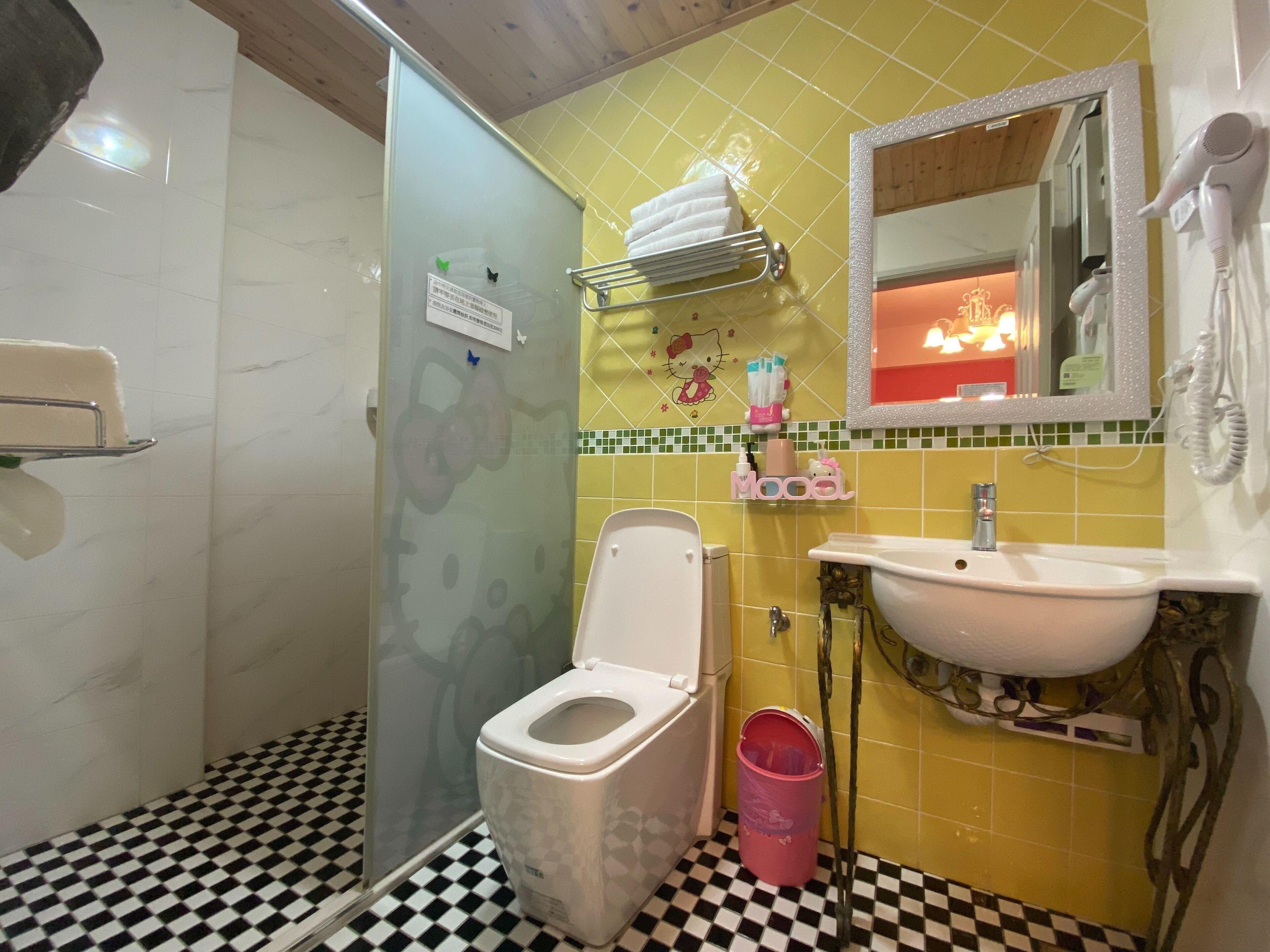 A bathroom with a toilet, sink, and shower.