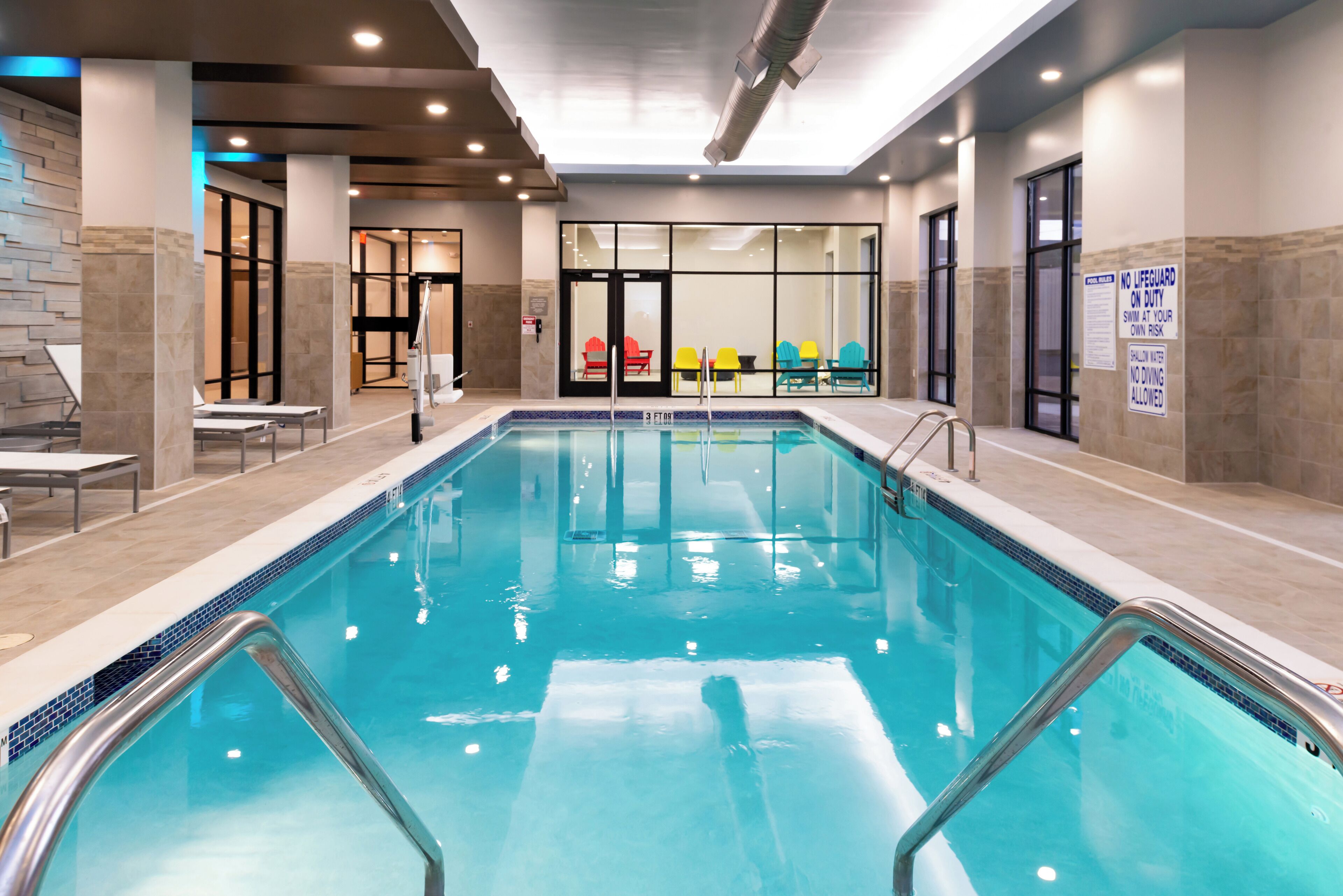 Una piscina techada, sillones reclinables de piscina