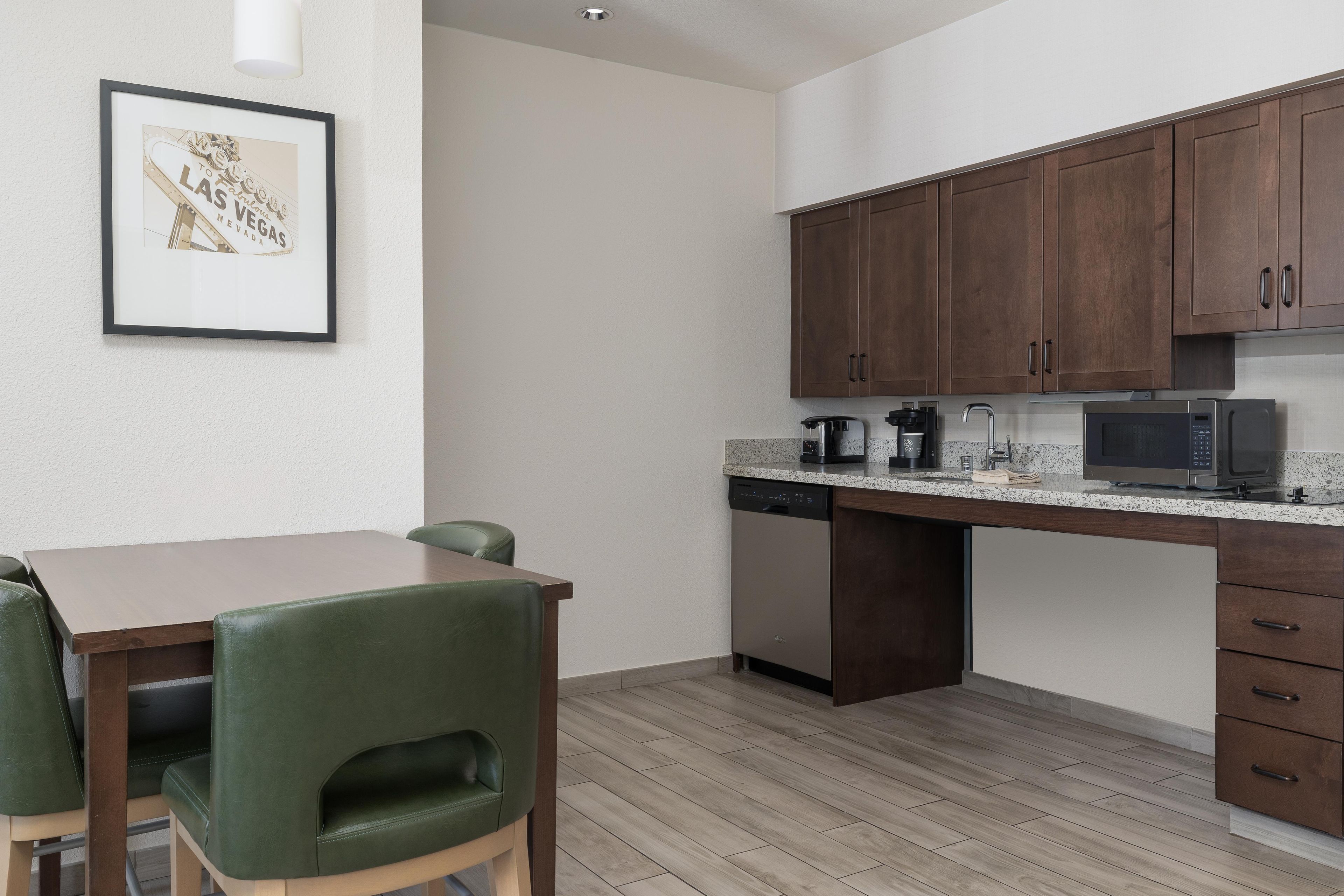 Una cocina moderna con armarios de madera, lavavajillas integrado y microondas.