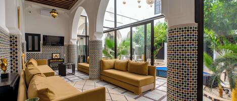 A spacious living area with a sofa set, a coffee table, and a decorative vase.