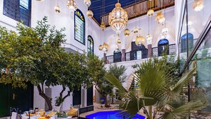 An indoor courtyard with a pool, seating area, and hanging chandeliers. - Riad Dar Dialkoum (Marrakech)