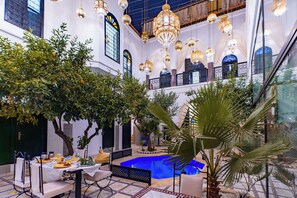 An indoor courtyard with a pool, seating area, and hanging chandeliers. - Riad Dar Dialkoum (Marrakech)