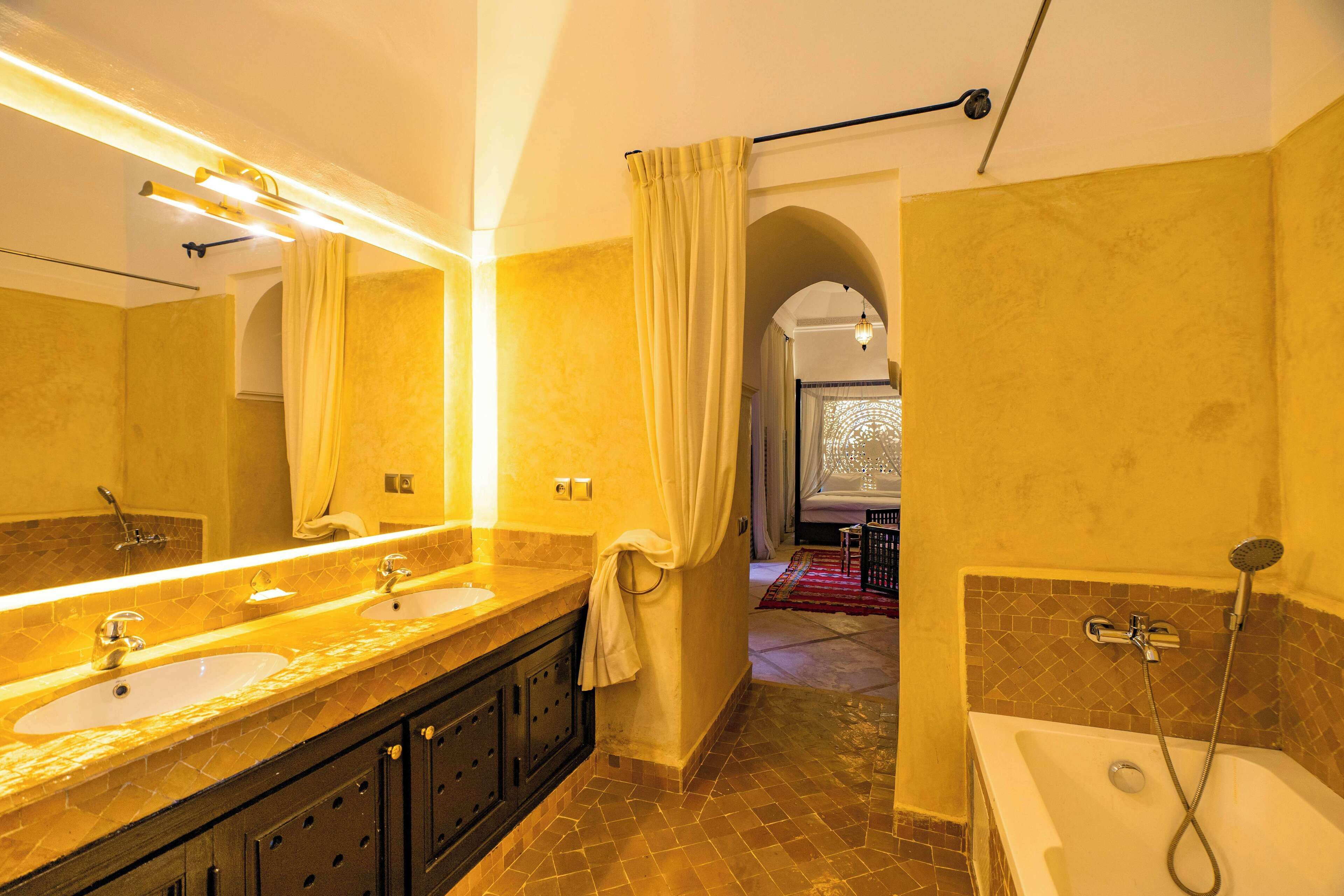 A bathroom with two sinks, a bathtub, and a large mirror.