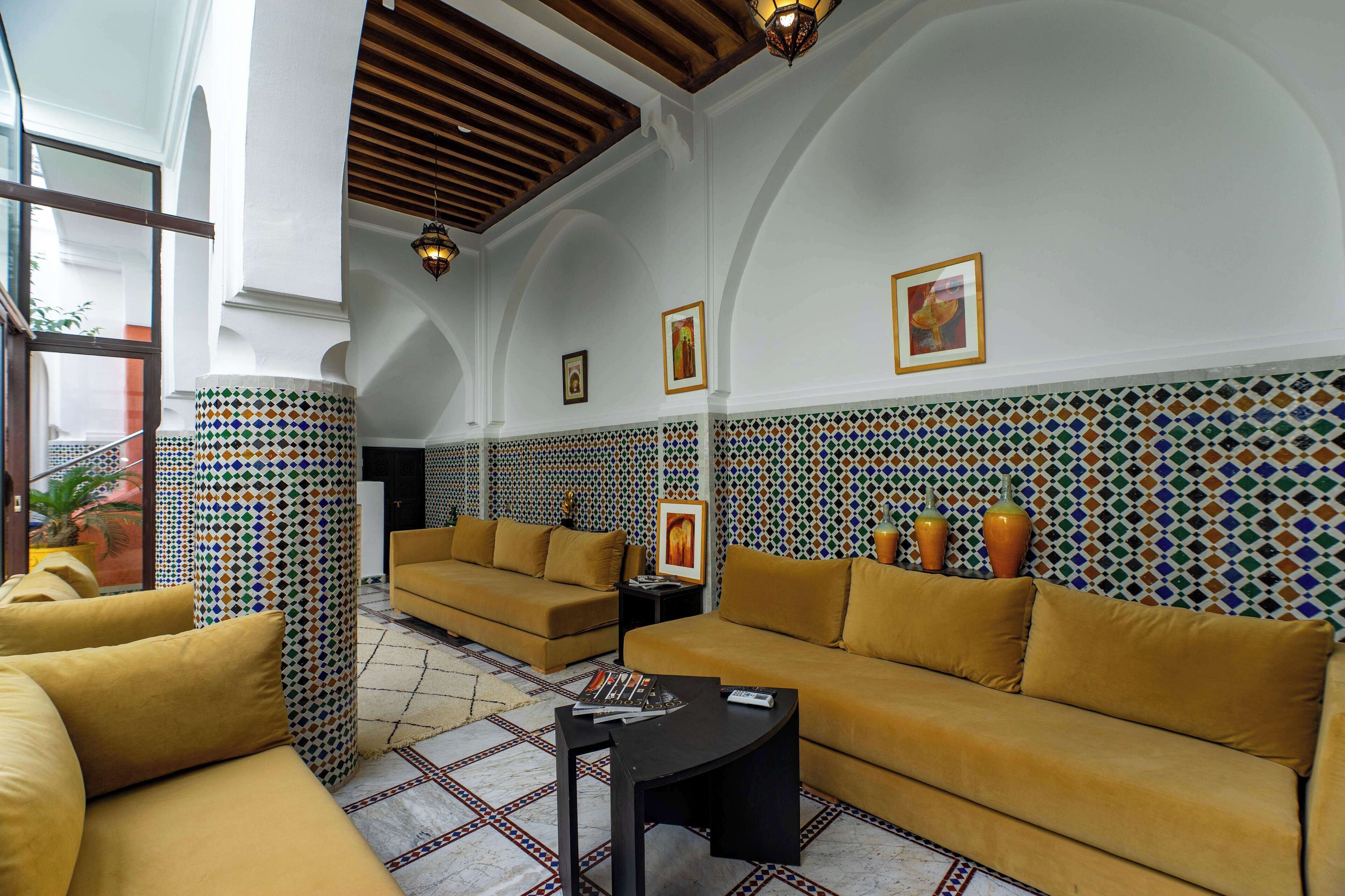 A spacious living area with two sofas, a coffee table, and a patterned wall.