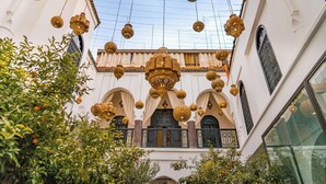 A courtyard with hanging lanterns, arches, and a central decorative element. - Riad Dar Dialkoum (Marrakech)