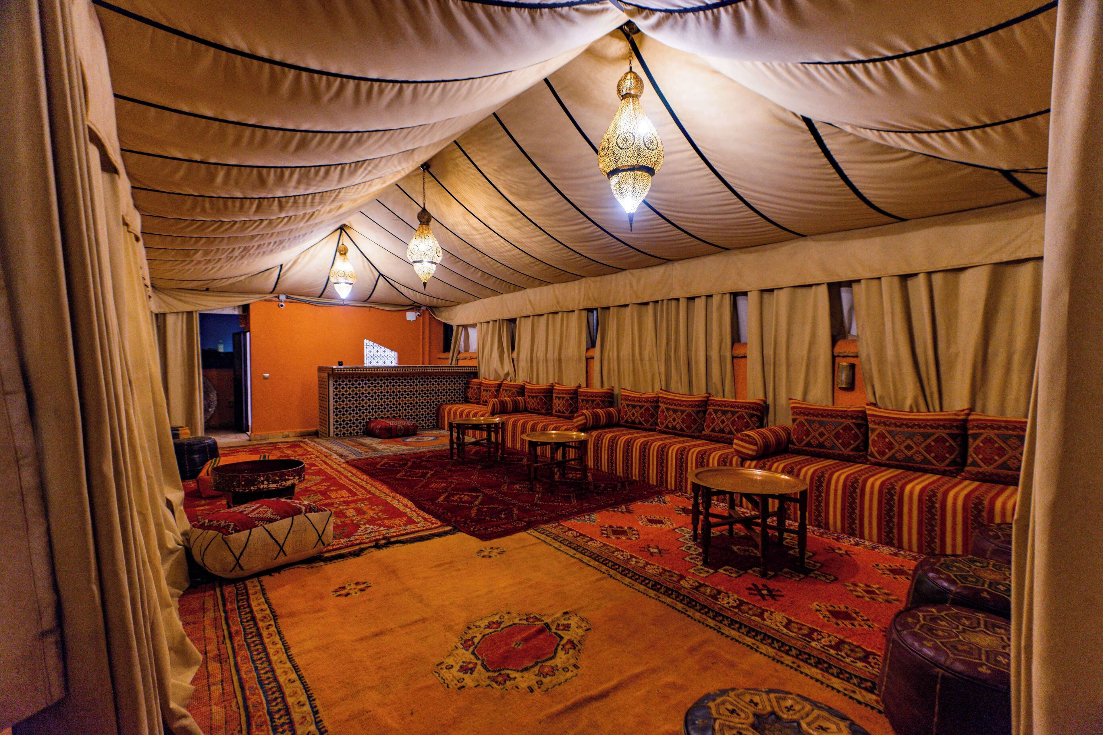 A tented room with a sofa, ottoman, and a small table.