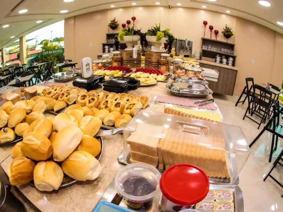 Un bufé con diferentes opciones de comida, incluyendo pan, pastelería y postres.