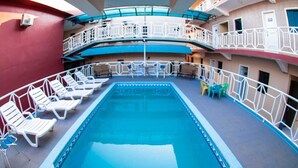 A pool area with lounge chairs and a pool on a cruise ship deck. - Por do Sol Hotel (Santarém)