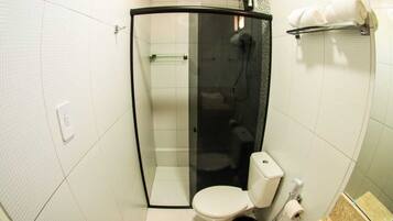 A modern bathroom with a glass-enclosed shower, a toilet, and a sink.