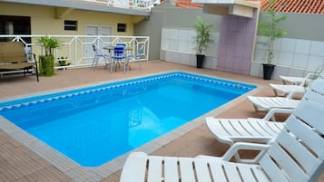 Alberca al aire libre y camastros