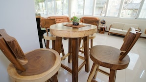 Una mesa redonda de madera con cuatro sillas, un sofá y una mesita con una planta.