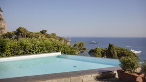 Una piscina con vista al mar y barcos.